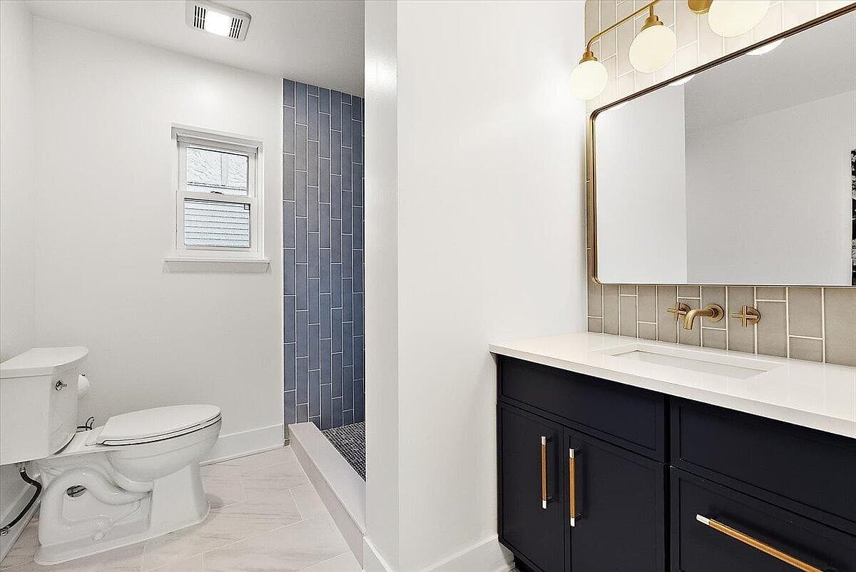 Unstaged bathroom view highlighting the vertical wall tiles