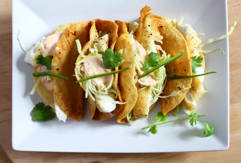 crispy fish tacos with a spicy yogurt sauce