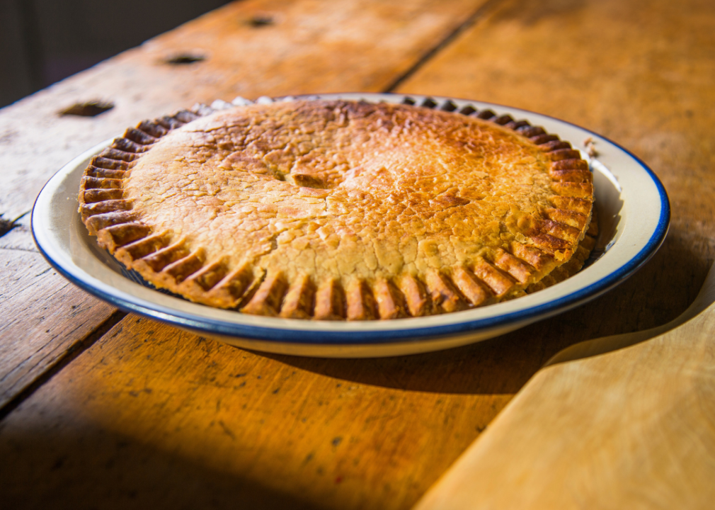 Robin pie A whole pie with a flaky, golden crust on a white ceramic plate.