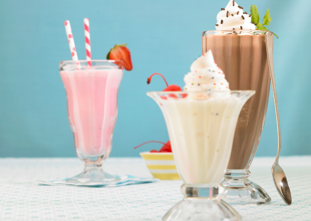 Malted milkshakes Three milkshakes topped with whipped cream in tall glasses: the one on the left is light pink, the one in the middle is light brown, and the one on the right is light chocolate brown.