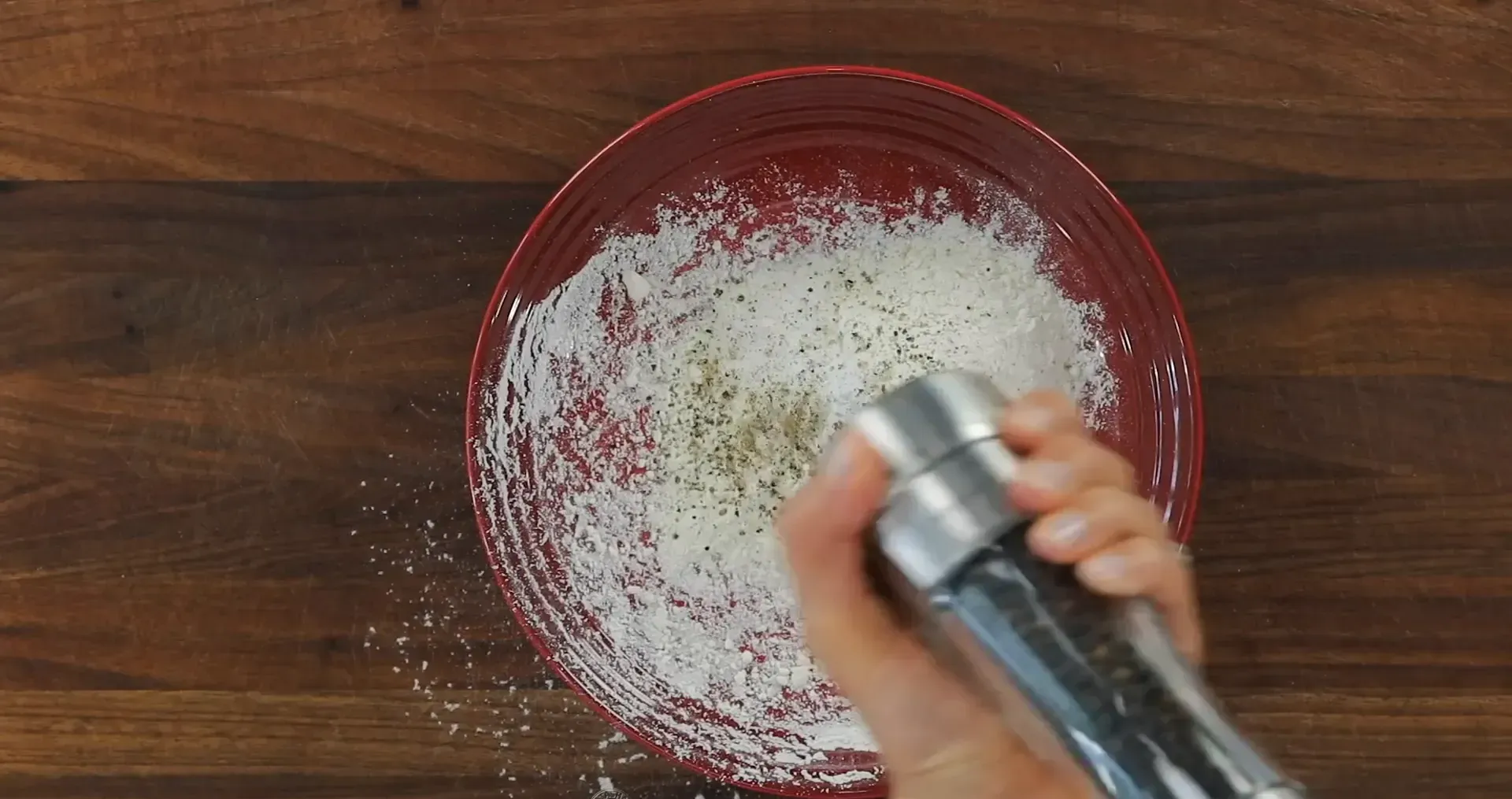 Mixing flour, salt, and pepper.