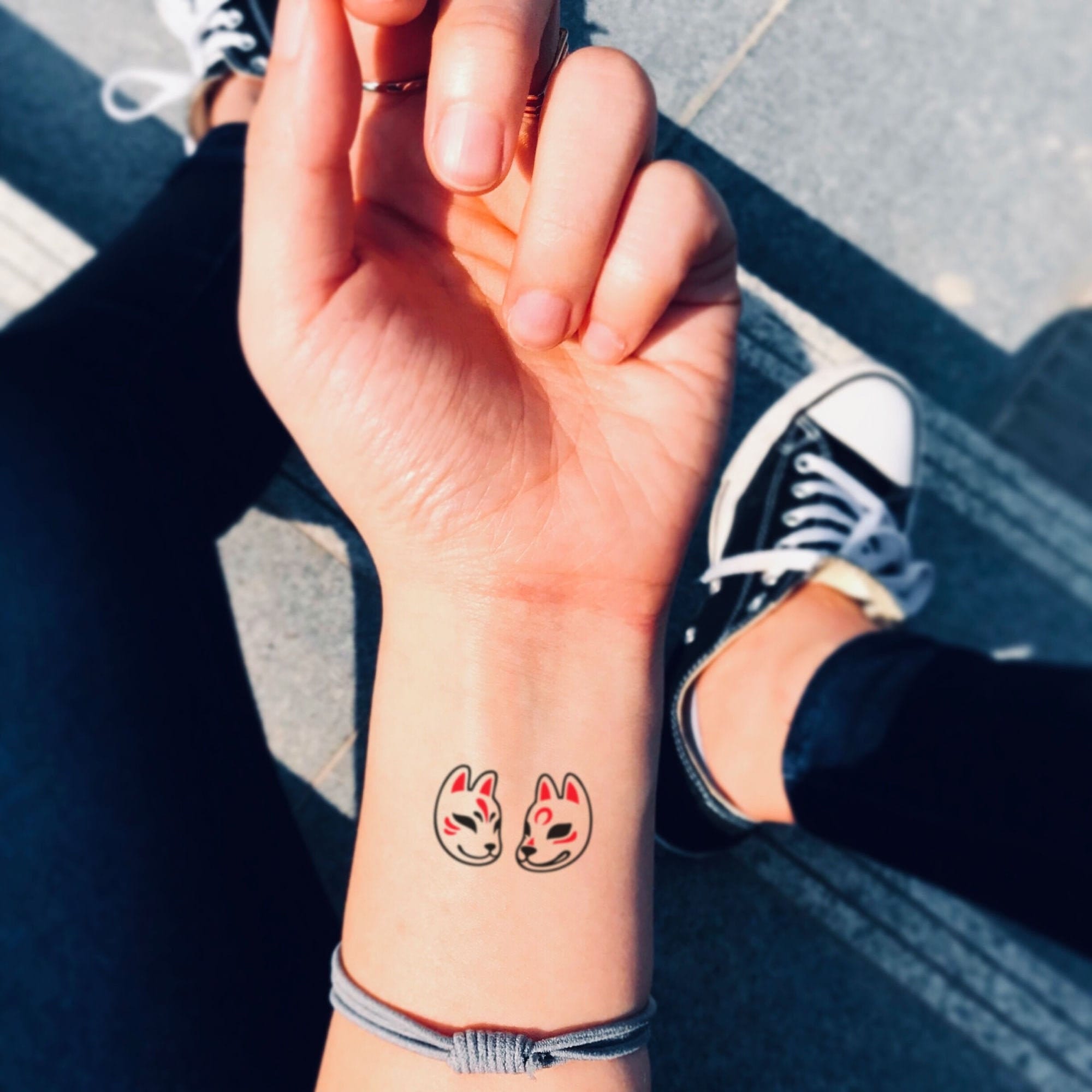 a small Japanese tattoo with a fox mask