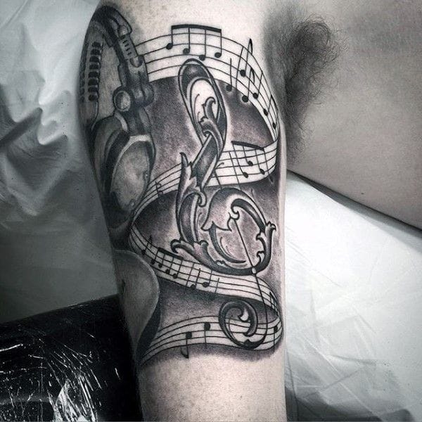 an upper arm tattoo with music notes