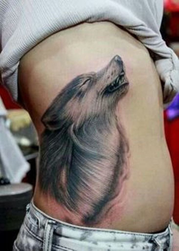 a ribs tattoo with a wolf head silhouette