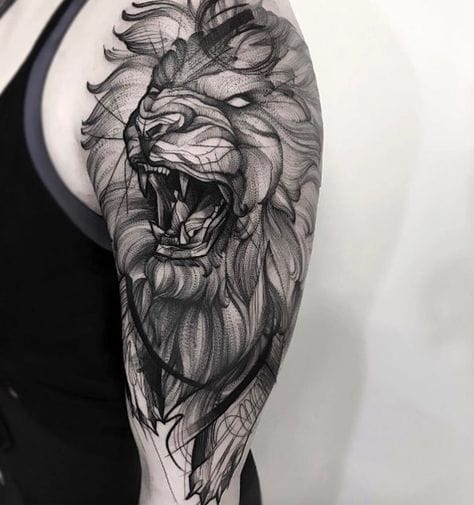 upper arm with lion tattoo in blackwork style