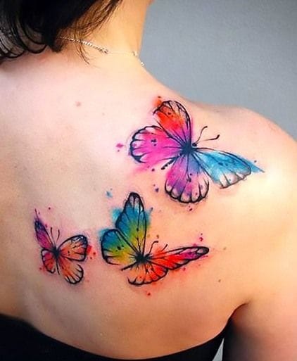 upper arm with butterfly tattoo in vibrant colors
