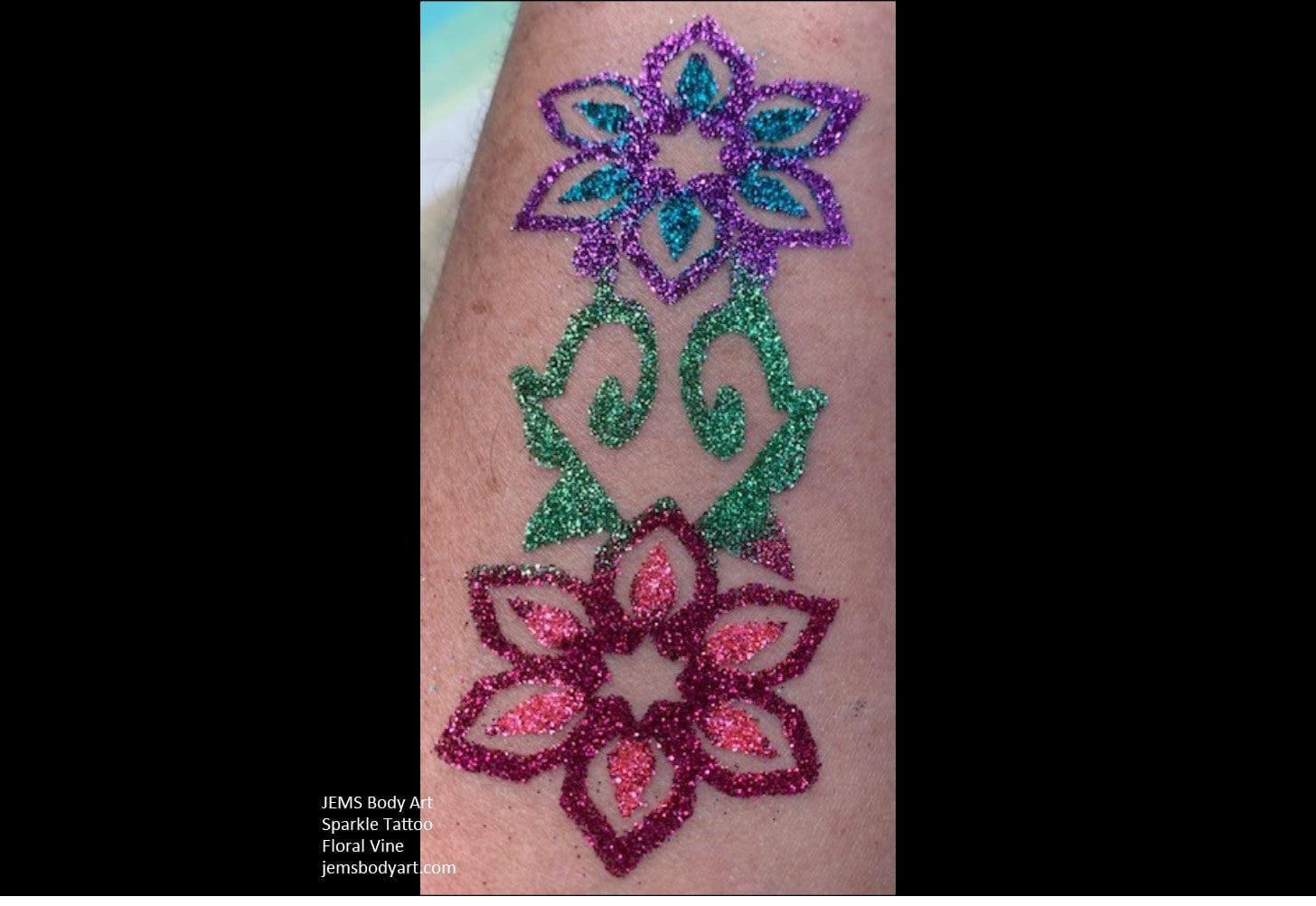 a glitter tattoo with a floral glitter vine