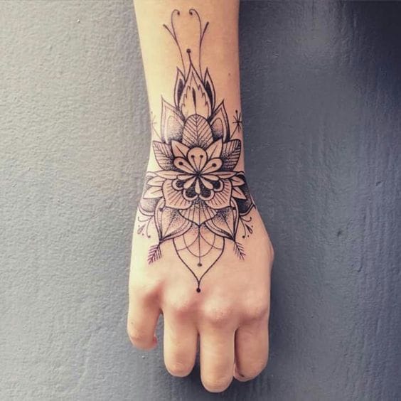 Delicate linework transforms this wrist into a canvas of sacred geometry, where mandala petals unfold like ancient prayers whispered in ink. The seamless flow from forearm to hand creates an enchanting bracelet effect that celebrates both botanical beauty and spiritual symbolism. ✨