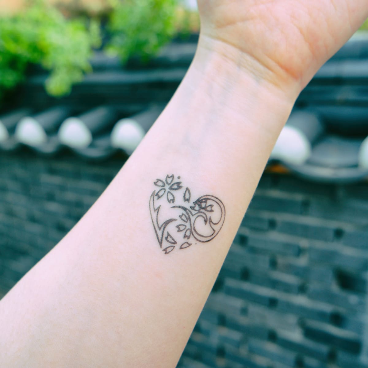 Delicate linework transforms the inner forearm into a canvas for this enchanting botanical heart design. The intricate floral motifs seem to bloom naturally from within the heart's outline, creating a perfect harmony between love and nature's beauty. 🌿 Such thoughtful placement makes this piece visible yet intimate—a gentle reminder of growth and affection.