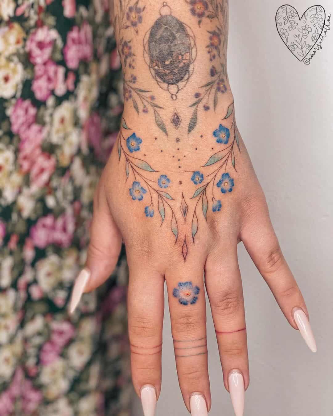 Delicate forget-me-nots cascade down this hand in a mesmerizing celestial dance, crowned by an ornate moon phase centerpiece that speaks to lunar feminine energy. The artist's masterful use of soft blue petals against intricate linework creates a botanical dreamscape that flows seamlessly from wrist to fingertip 🌙 A single bloom gracing the ring finger adds the perfect finishing touch to this enchanting floral constellation.