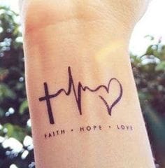 Delicate linework transforms the wrist into a canvas for life's most essential elements - faith, hope, and love beautifully captured in a minimalist heartbeat design. The elegant cross seamlessly flows into cardiac rhythm lines before blossoming into a heart symbol, creating a meaningful narrative that speaks to both spiritual devotion and the pulse of human connection. ✨