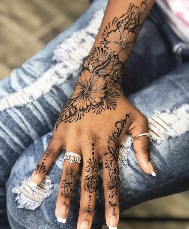 Delicate hibiscus blooms cascade down this forearm and hand in stunning black ink, creating a seamless garden that flows like nature itself 🌺 The intricate linework and dotwork details give each petal incredible depth, while the strategic placement makes every hand gesture a work of art. Perfect proof that floral tattoos can be both feminine and fierce!