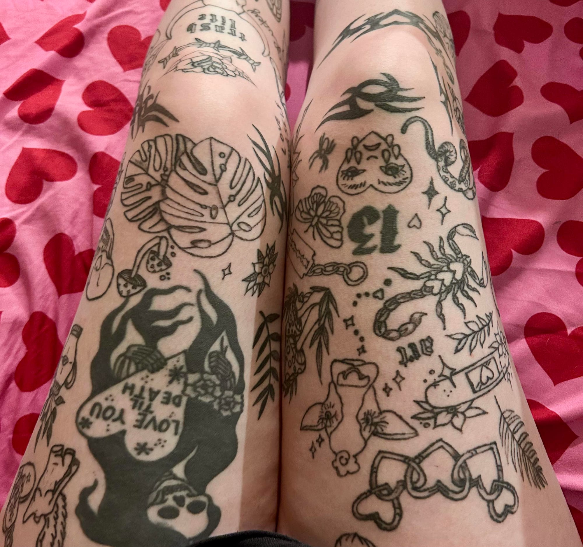 Flash art comes alive across these legs in a stunning patchwork of traditional tattoo motifs that tells a thousand stories. The bold black linework showcases classic designs from skulls and roses to swallows and sacred hearts, creating an authentic old-school tapestry that any tattoo enthusiast would instantly recognize 🖤 Every inch represents the timeless appeal of Americana flash, perfectly executed in that iconic bold, clean style.
