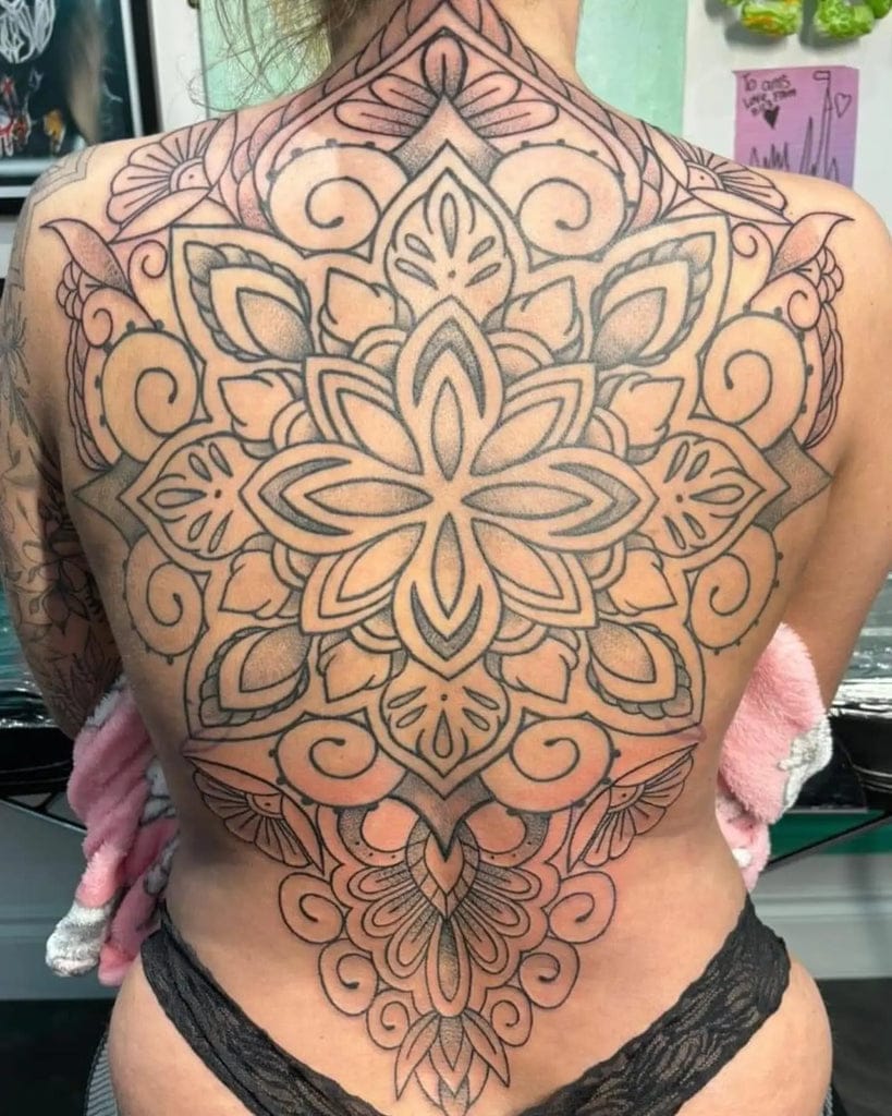 Intricate mandala artistry transforms this entire back into a mesmerizing canvas of symmetrical beauty ✨ The elaborate floral motifs and geometric patterns flow seamlessly from shoulders to lower back, creating a stunning full-coverage piece that celebrates sacred geometry. Every delicate line and ornamental detail showcases the incredible precision required for such an ambitious mandala design.