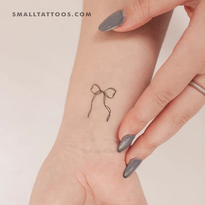 Delicate line work transforms a simple bow into pure elegance on this wrist placement. The minimalist design captures the essence of femininity with just a few graceful strokes, proving that sometimes the most understated tattoos make the strongest statement. 🎀