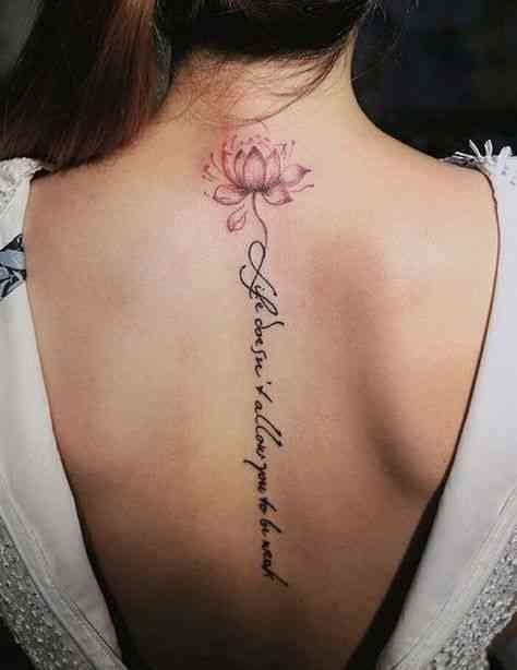 A delicate pink lotus blooms at the nape of the neck, its petals rendered in soft watercolor hues that seem to float above the skin. The elegant cursive script cascades down the spine like a gentle waterfall, creating a stunning vertical composition that transforms the back into living art. The seamless flow from flower to text demonstrates how meaningful words can become as beautiful as any botanical masterpiece 🌸