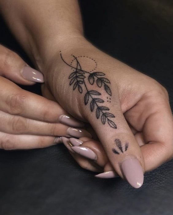 Delicate botanical artistry flows across the hand in this minimalist masterpiece, featuring graceful leaves that seem to dance from wrist to fingertip. The fine line work and geometric accents create a perfect balance between organic beauty and modern design sensibility. Hand placement makes this piece a constant reminder of growth and natural elegance 🌿