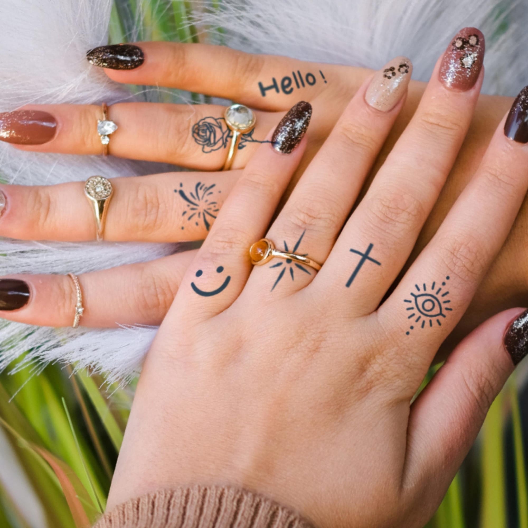 Delicate finger tattoos transform hands into a whimsical canvas of self-expression, featuring playful symbols like