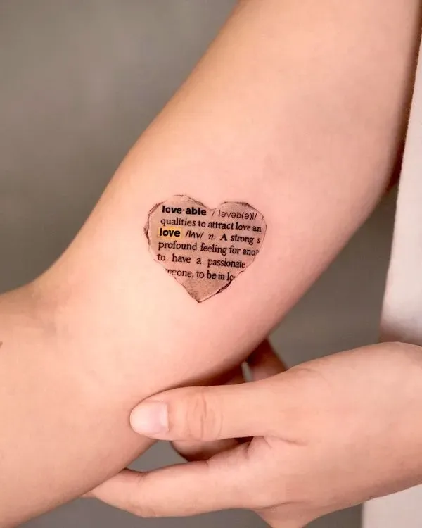 Dictionary pages transformed into wearable art ✨ This heart-shaped temporary tattoo cleverly incorporates the definition of