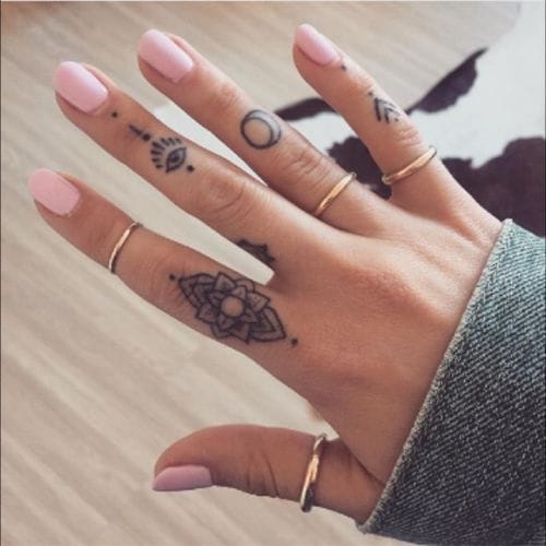 Delicate mandala designs dance across these fingers like whispered secrets, creating an intimate gallery of geometric beauty that moves with every gesture. The intricate dotwork and sacred symbols transform ordinary hands into a canvas of spiritual artistry, while dainty gold rings add the perfect complement to this ethereal finger tattoo collection. ✨