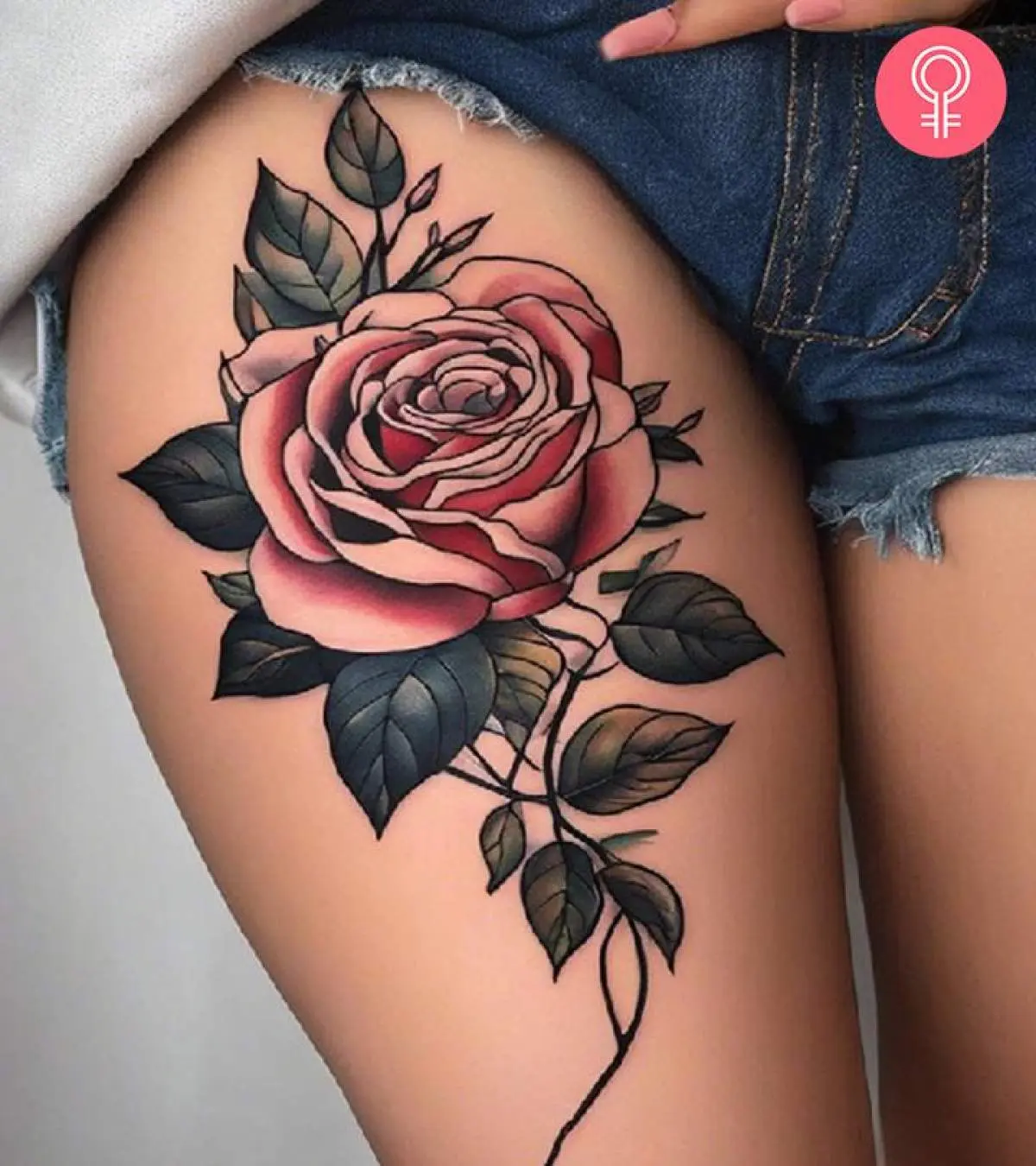 Delicate petals unfurl in perfect harmony across this thigh placement, where soft pink roses meet deep charcoal leaves in stunning contrast. The traditional American style shading brings dimensional depth to every curve, while the flowing stem creates an elegant line that follows the natural contours of the leg 🌹 Bold yet feminine, this piece proves that classic rose tattoos never go out of style.