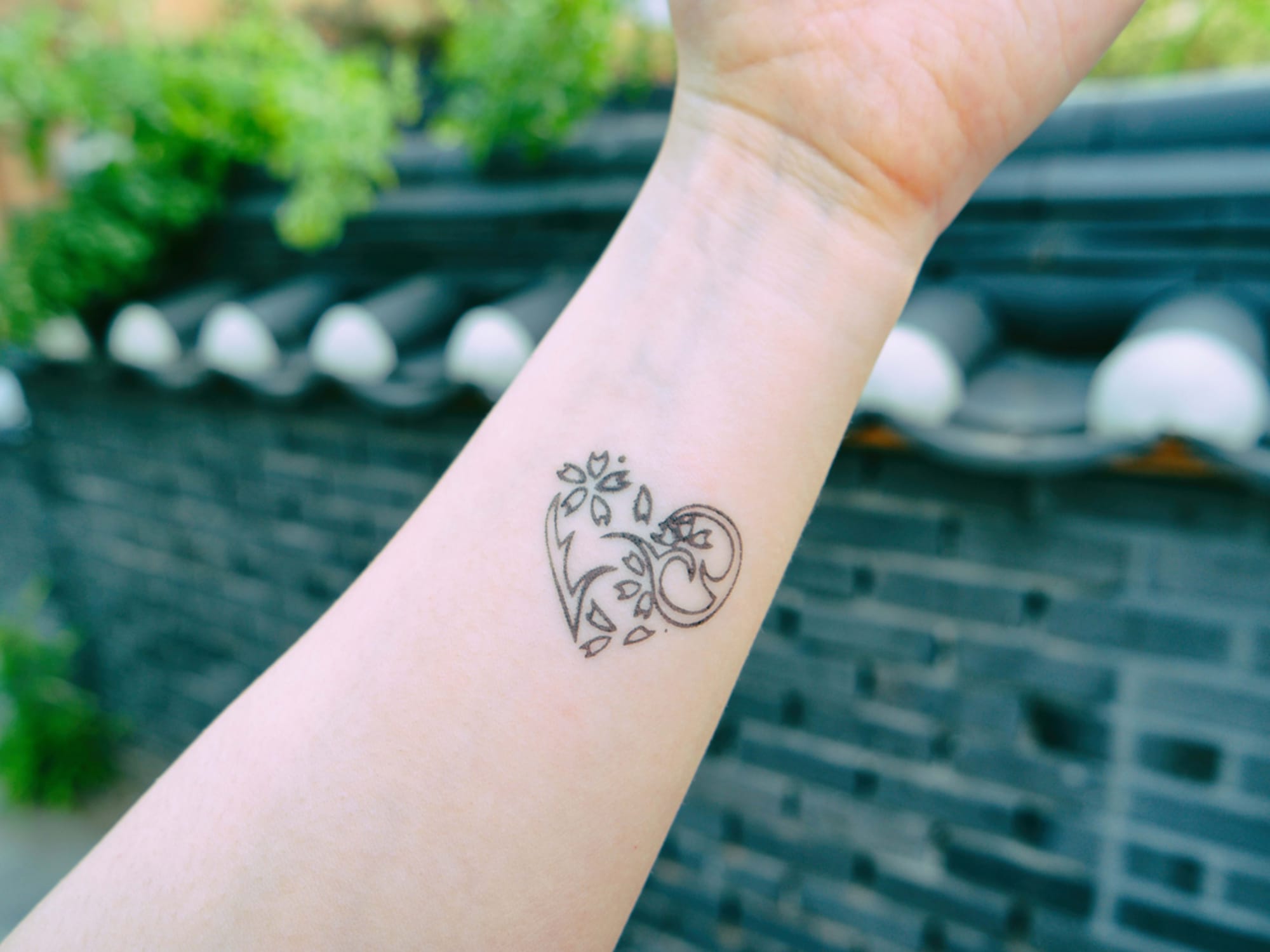 Delicate linework transforms the forearm into a canvas for this enchanting floral vine design, where graceful curves and botanical elements dance together in perfect harmony. The minimalist black ink style creates an organic flow that follows the natural contours of the arm, making it feel like the design grew there naturally 🌿