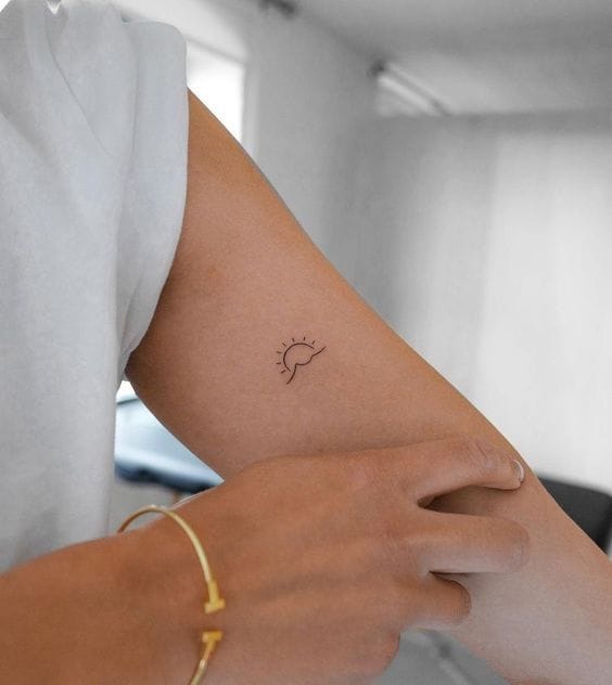 Delicate line work transforms a simple lightbulb into pure inspiration with this minimalist upper arm piece. The fine black ink captures that perfect