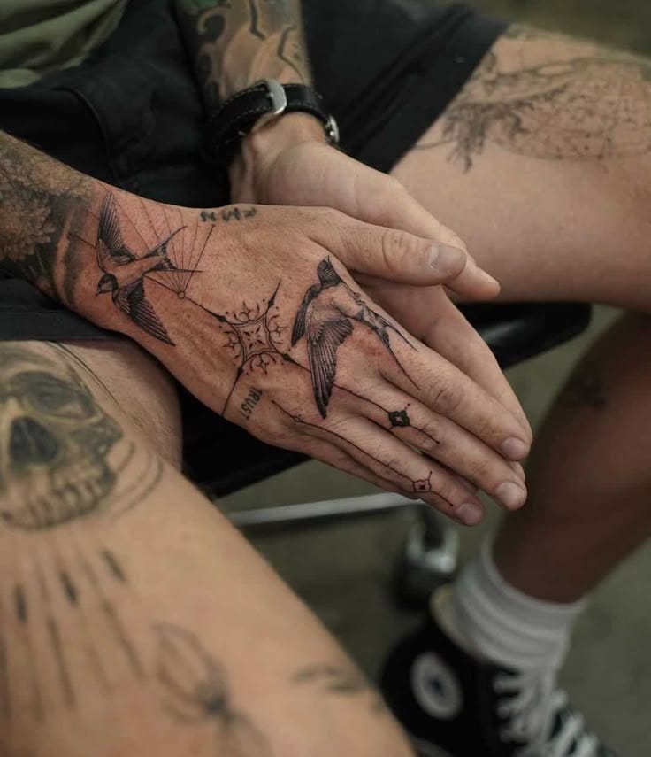 Delicate birds take flight across weathered palms in this breathtaking hand tattoo that transforms everyday gestures into poetry. The fine line work creates an enchanting scene where swallows dance between fingers, turning cupped hands into a sanctuary of ink and skin. A beautiful reminder that freedom and beauty can literally rest in your hands ✨