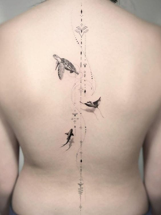 Flowing like an underwater current down the spine, this ethereal piece transforms the back into an oceanic dreamscape where sea turtles, rays, and sharks dance through delicate dotwork patterns. The geometric compass elements at top and bottom create perfect symmetry, while the fine line technique gives each marine creature an almost weightless quality as they navigate this vertical aquatic journey. 🌊