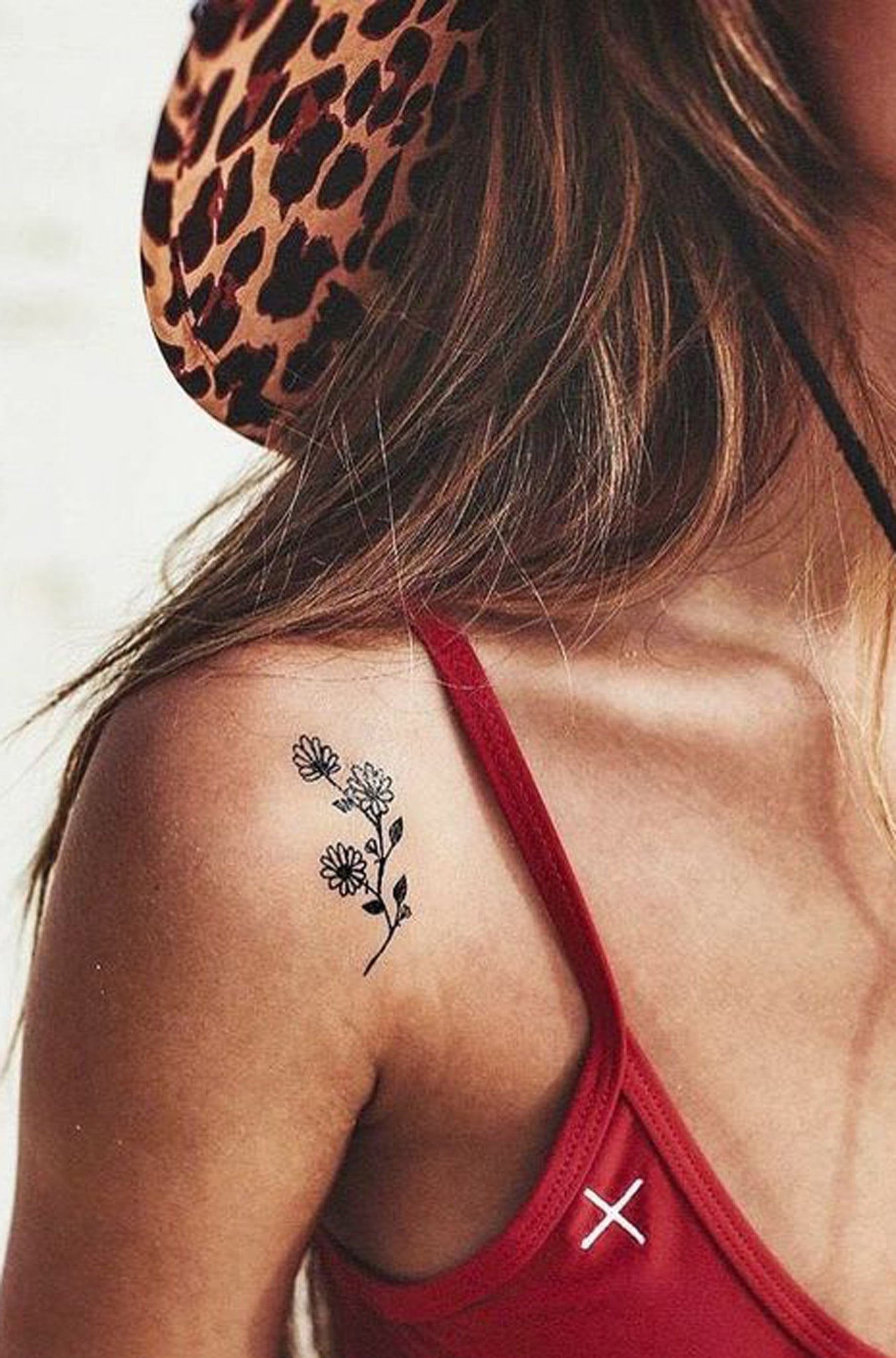 Delicate wildflowers bloom across the shoulder blade in this minimalist botanical design that perfectly captures nature's gentle beauty. The fine line work and strategic placement on the back shoulder creates an effortlessly feminine look that's both subtle and striking when revealed. This piece proves that sometimes the most elegant tattoos are the ones that whisper rather than shout 🌸