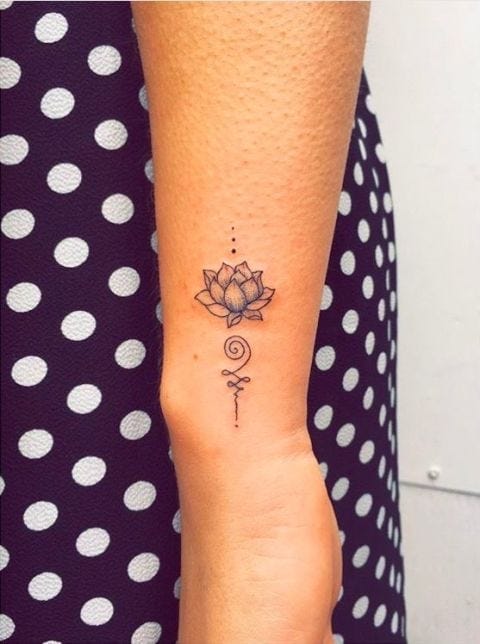 Delicate line work transforms this forearm into a canvas of spiritual symbolism, featuring a beautifully detailed lotus blossom that flows seamlessly into an intricate geometric design below. The minimalist black ink style perfectly captures the lotus's meaning of growth and enlightenment, while the vertical placement creates an elegant focal point that draws the eye naturally down the arm. 🪷