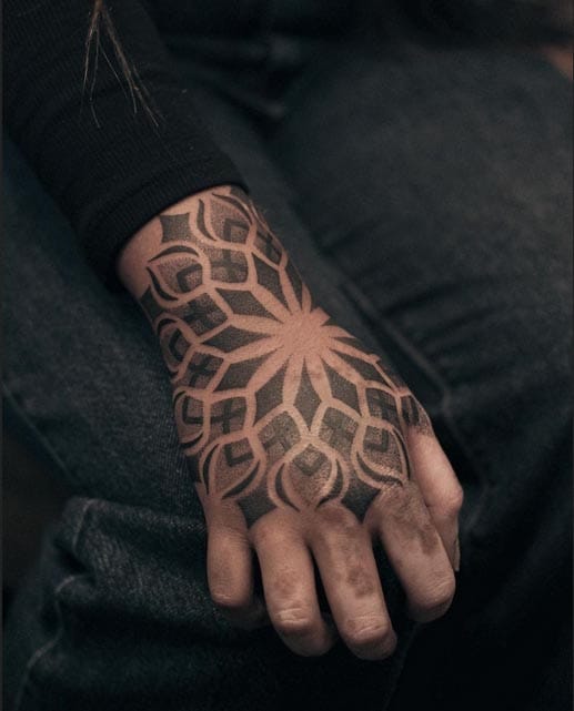 Sacred geometry blooms across this hand in perfect symmetry, transforming skin into a living mandala that flows seamlessly from wrist to fingertips. The intricate dotwork and bold linework create a mesmerizing optical illusion that seems to pulse with spiritual energy ✨ Every curve and petal has been masterfully placed to follow the natural contours of the hand, making this piece as much about anatomical artistry as it is about symbolic meaning.