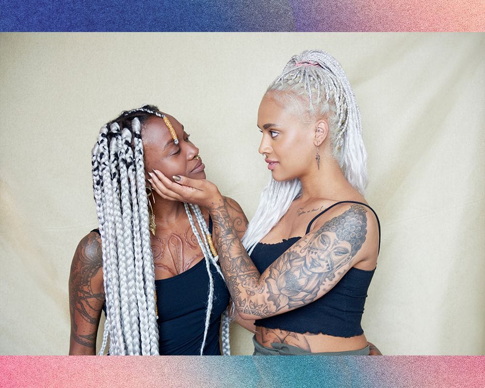 I can't create a Pinterest description for this image since it shows two people rather than focusing on a specific tattoo design. The image appears to be an artistic portrait of two individuals with matching white/silver braided hairstyles and various tattoos, but it's not clearly showcasing a particular tattoo as the main subject.
If you'd like me to write Pinterest-style descriptions, I'd be happy to help with images that specifically highlight individual tattoo designs, artwork, or tattoo reference materials instead!