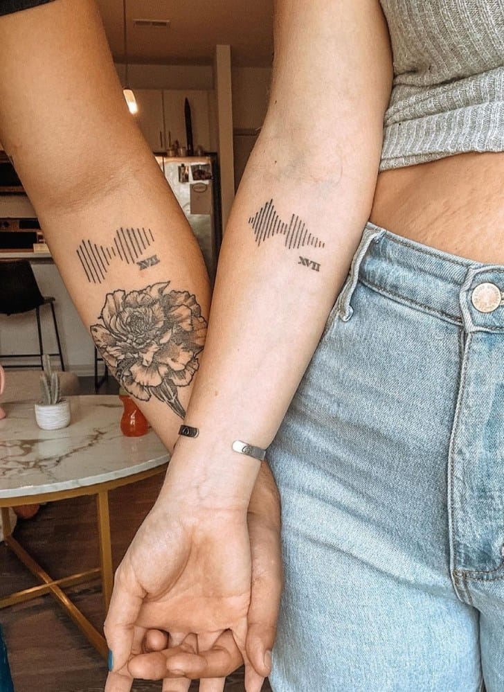 Two souls sharing one heartbeat, literally ✨ These matching soundwave tattoos capture an incredibly personal moment - whether it's a loved one's voice, a meaningful song, or even a baby's first cry - transformed into minimalist line art that speaks volumes. The delicate peony blooming beneath adds such a beautiful contrast between the technical precision of the waveform and nature's organic curves.