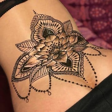 Delicate mandala petals bloom across this shoulder blade placement, where intricate linework creates stunning dimensional depth through layered geometric patterns. The cascading beaded chains add movement and femininity to this bold black ink masterpiece, proving that ornate doesn't always mean overwhelming ✨