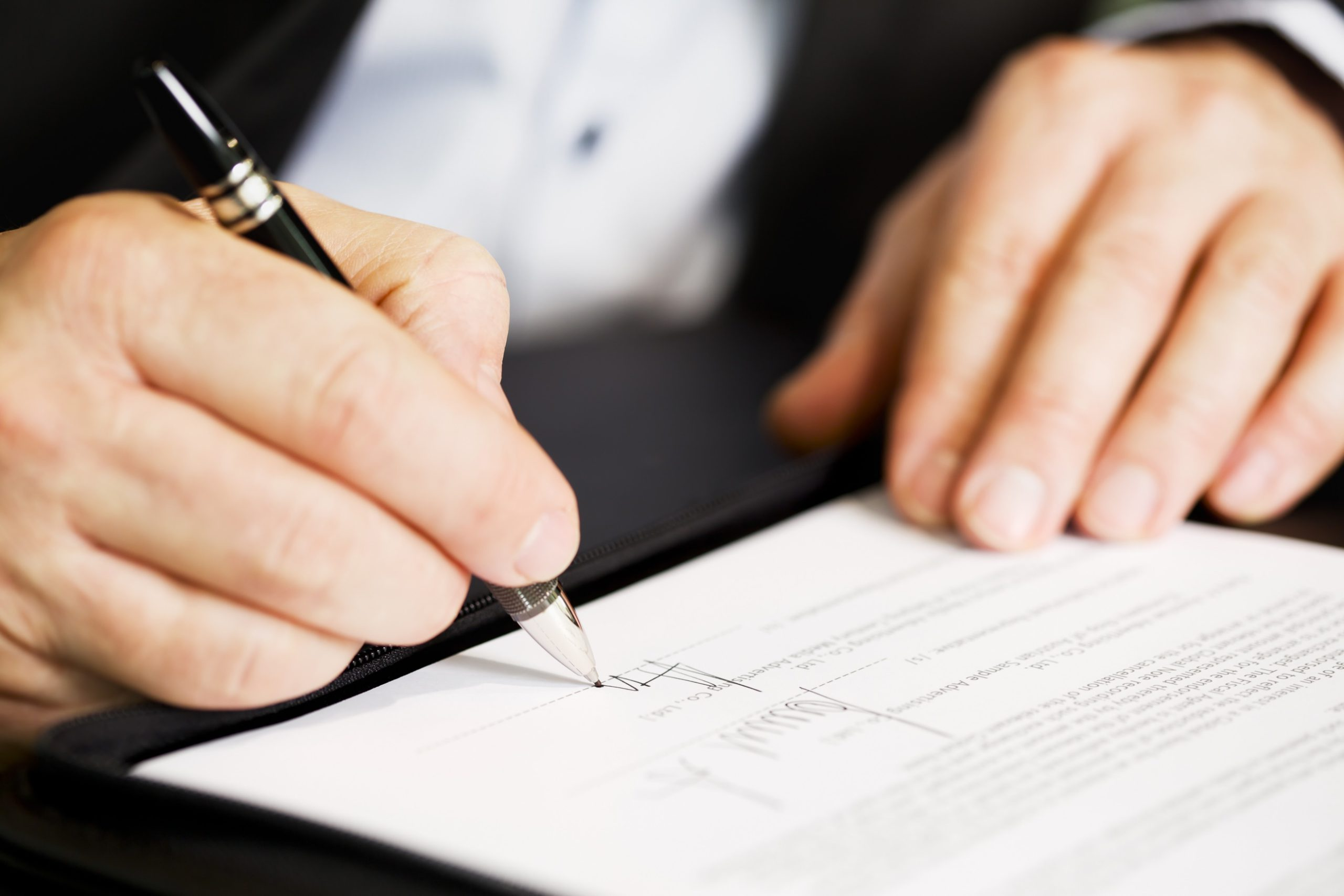 man signing - How to Dissolve an LLC in New Jersey