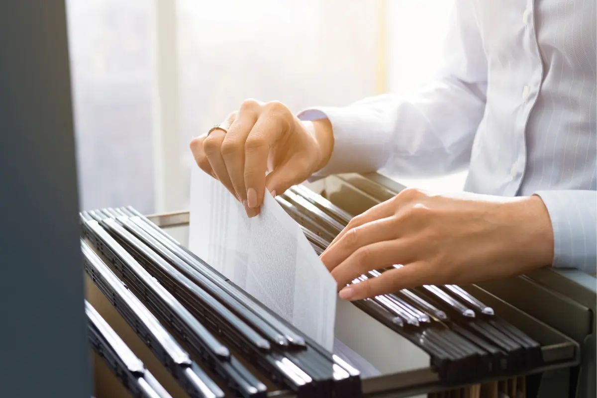 man taking a paper out of cabinet - How To Close A Business With The IRS