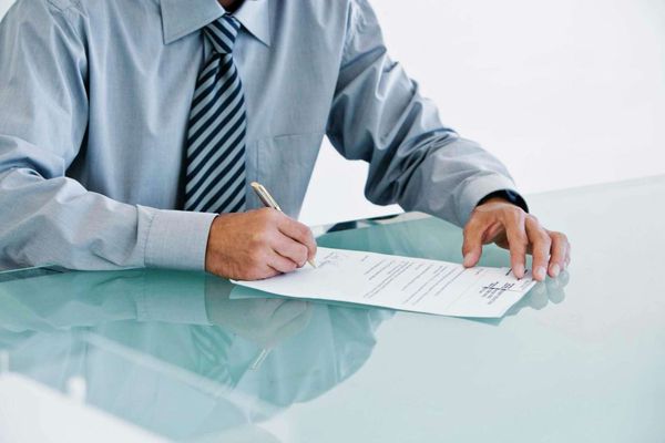 man signing document - How to Dissolve an LLC in New York