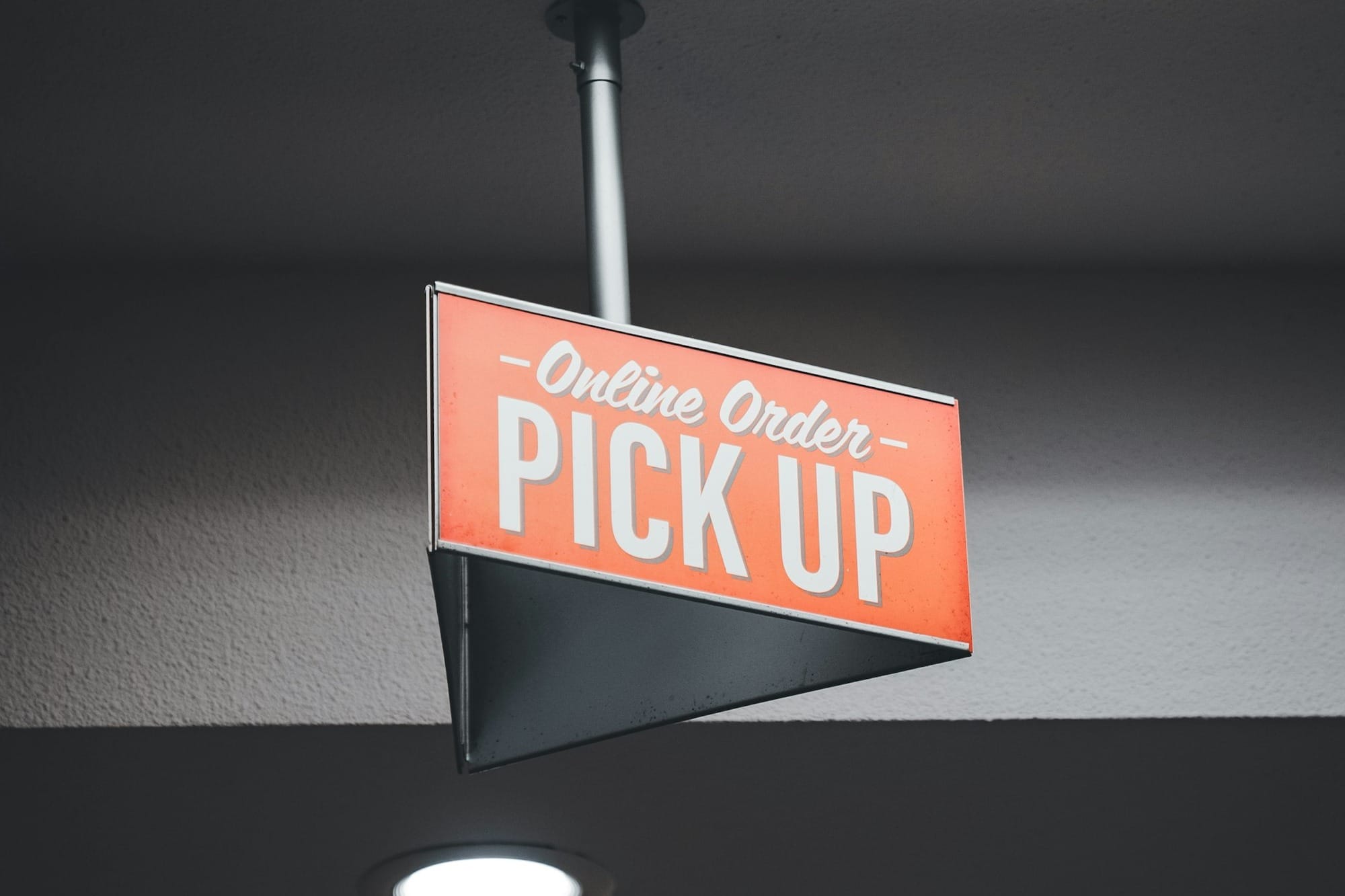 a sign hanging from the ceiling of a fast food restaurant