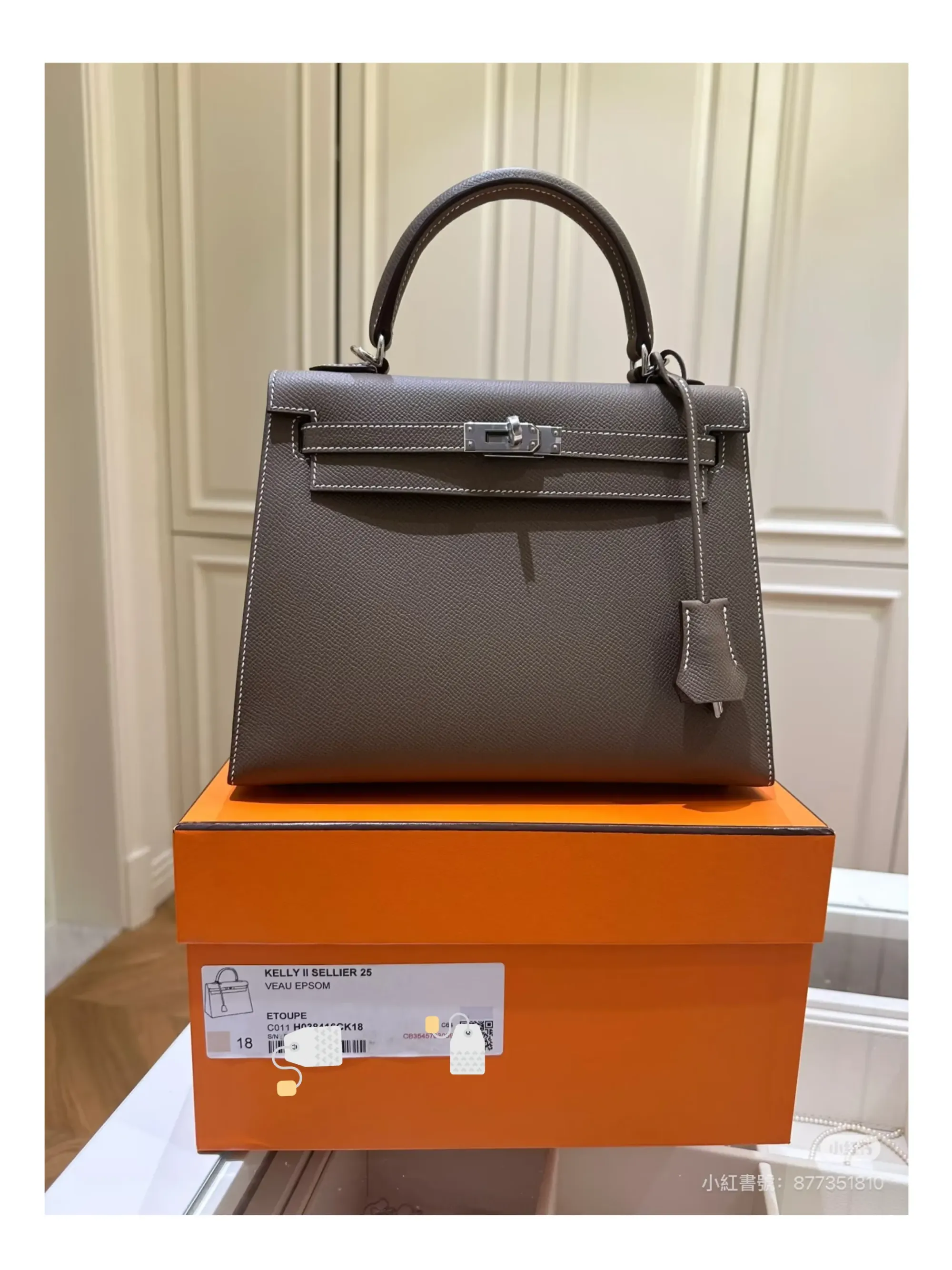 Hermès 手袋橙色盒外貼有產品標籤,標示皮質、顏色、型號、序號(s/n)及 QR Code 等資料。此類情況於中國內地市場相當常見。