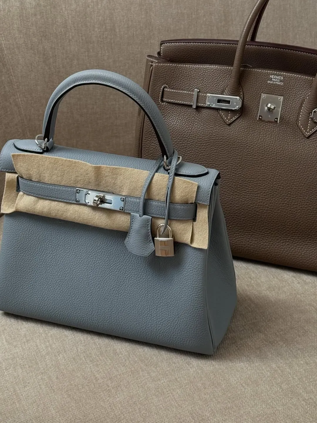 Hermès Kelly（Gris Pantin）與&nbsp;Birkin（Etoupe）兩款中性色調對比展示，配以銀色金屬（PHW），整體感覺柔和而沉穩，呈現冷暖灰之間嘅平衡與層次感。