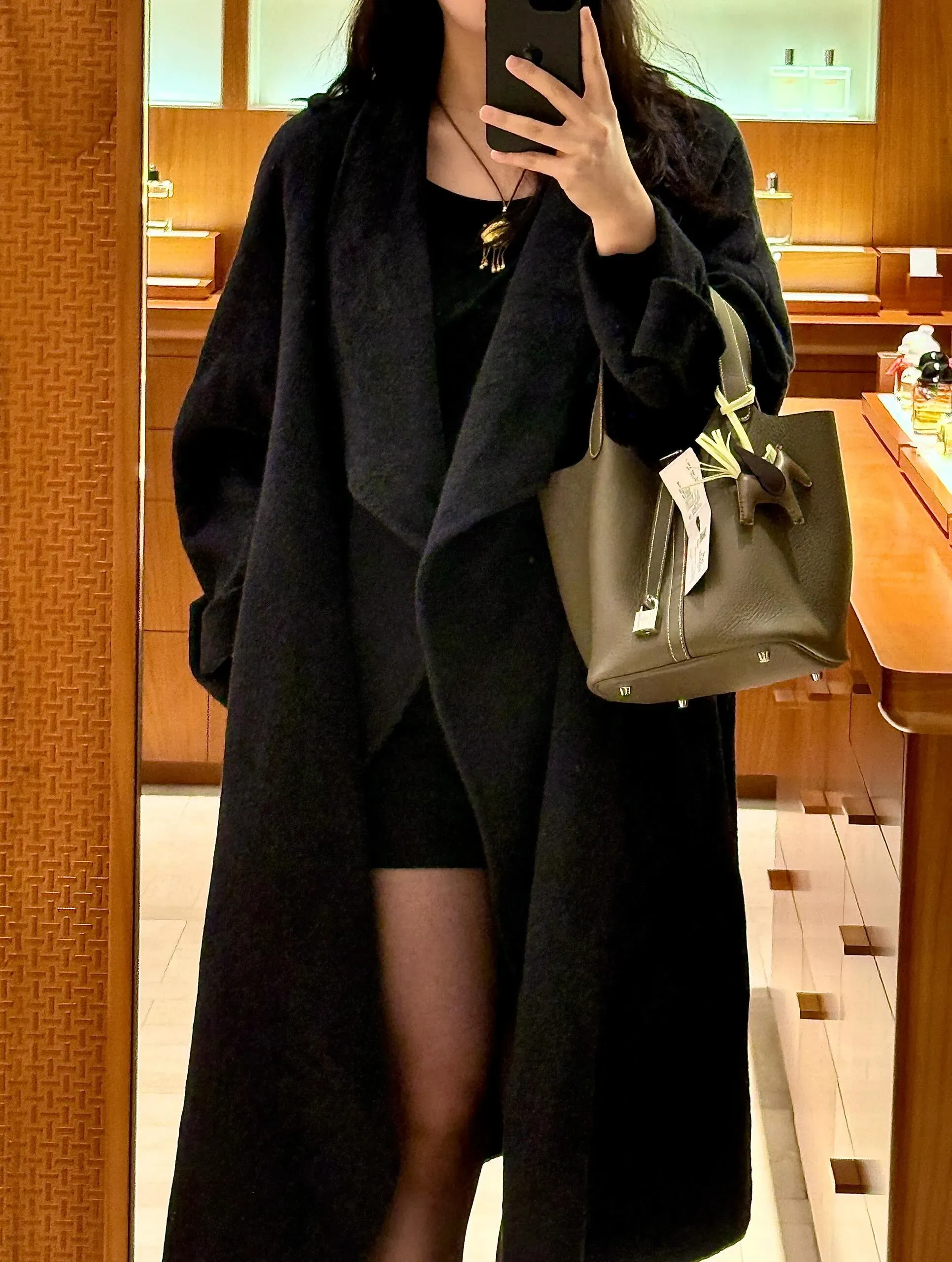 Etoupe&nbsp;與黑色服裝的近距離對比。灰啡色調在不同光線下會呈現變化，成為造型中的視覺重點。