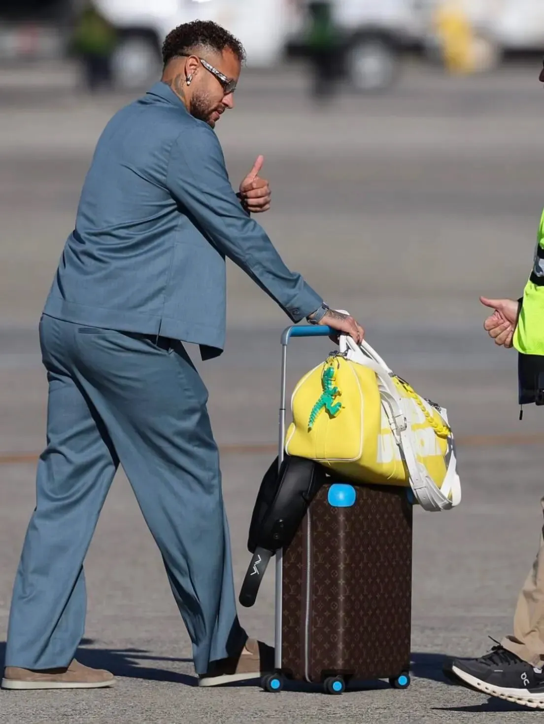 Neymar Jr.攜帶Louis Vuitton Keepall Bandoulière旅行袋,袋上掛有恐龍吊飾。