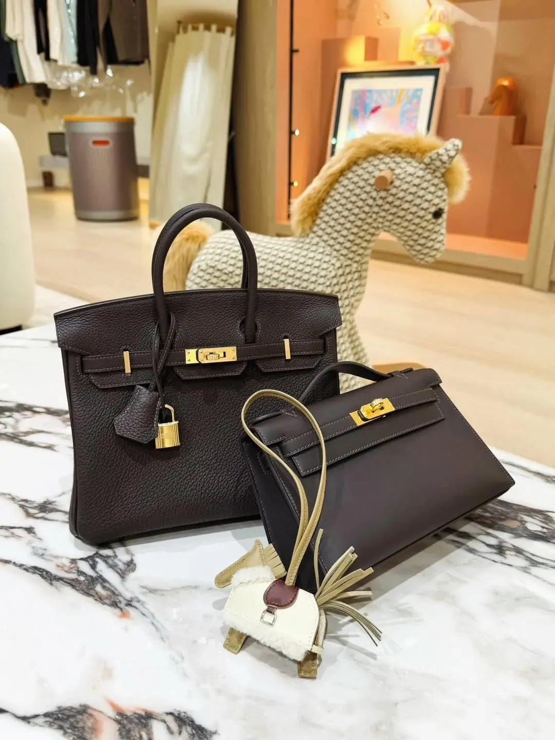 Hermès Birkin 25 及 Kelly Pochette也就是我們常常俗稱的「Mini Kelly 一代」P Bai Brun(駿馬棕/棗棕)實物圖片。Bai Brun屬2026年度重點新色之一,靈感來自栗色馬匹毛色。整體呈現深棕色調,並帶有豐富光影層次,因此被不少收藏圈玩家視為介乎Gold與Ebene之間嘅全新棕色選擇。