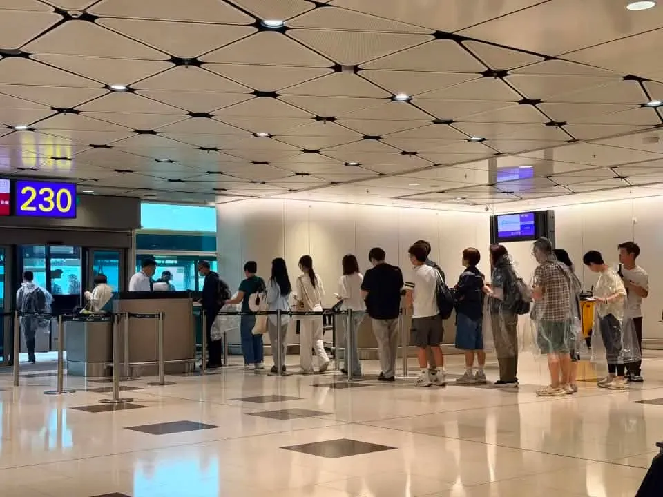 乘客於登機閘口著咗一次性雨褸,準備乘搭接駁巴士前往停泊於遠停機位(Remote Stand)的航機