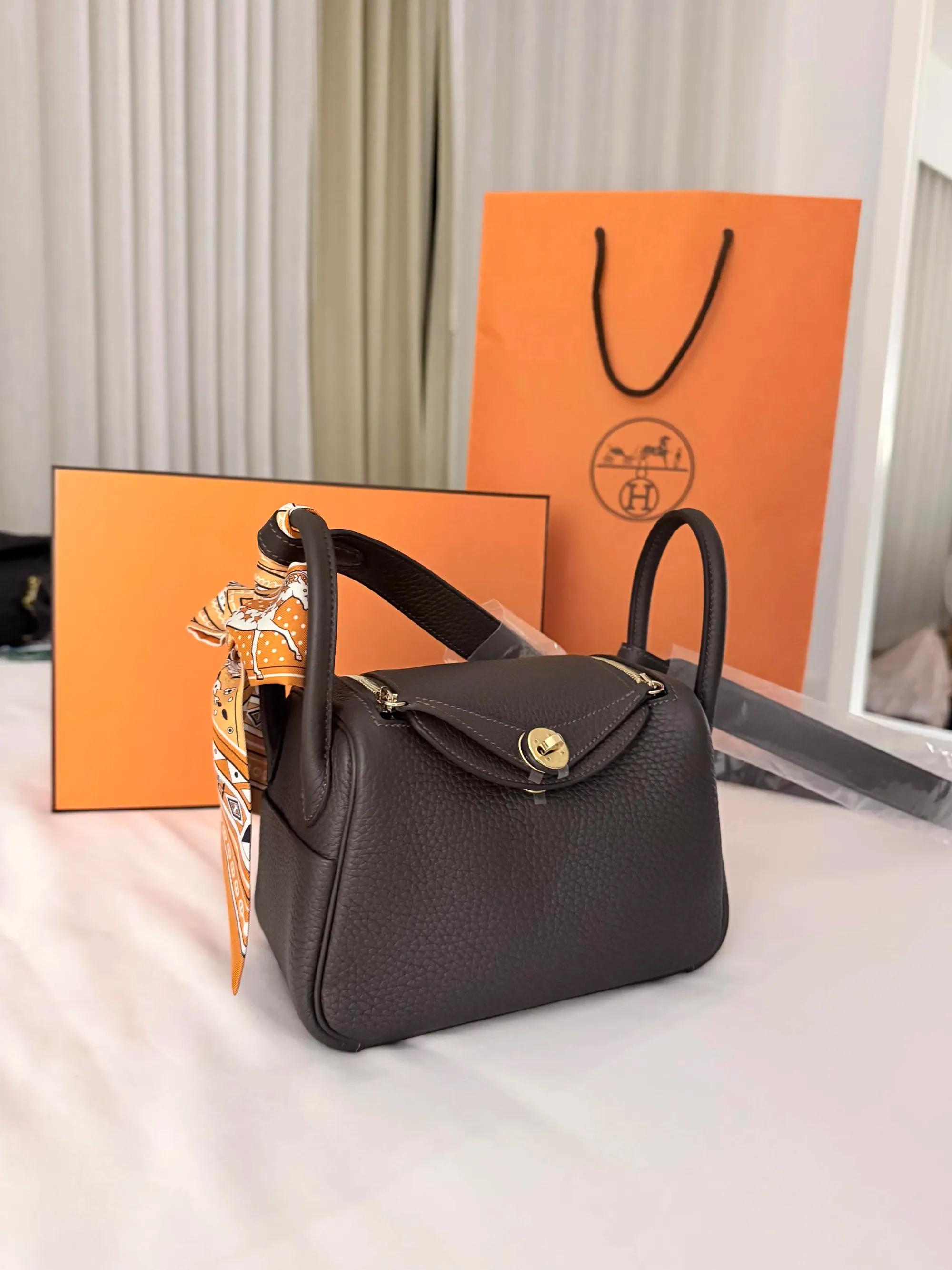 Hermès Mini Lindy Bai Brun(駿馬棕)實物圖片。Bai Brun屬Hermès 2026新色之一,靈感來自栗色馬匹毛色,呈現帶暖紅底調嘅深巧克力棕色,整體比一般深啡色更具層次感。