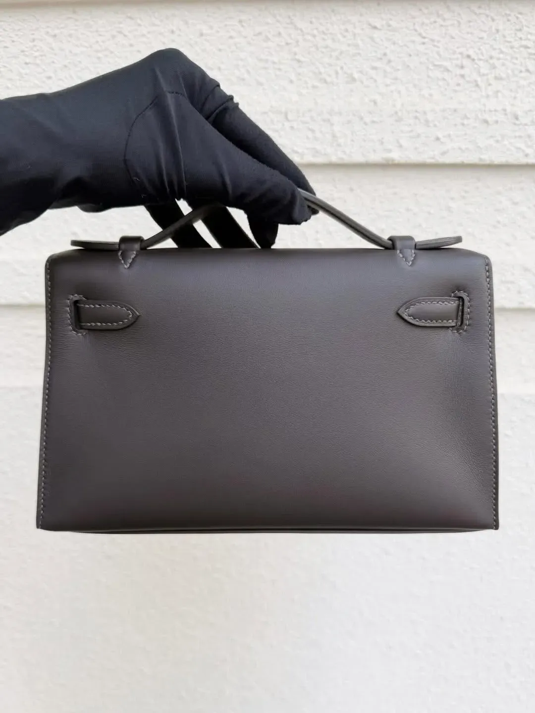 Hermès Mini Kelly I Bai Brun(駿馬棕/棗棕)T3 Swift皮革背面實物圖片。Bai Brun應用於Mini Kelly等小型袋款時,能呈現出較細膩嘅棕色層次。相比Gold更沉穩,比Ebene更具棕色辨識度,亦因此成為2026年度最受關注嘅新色之一。