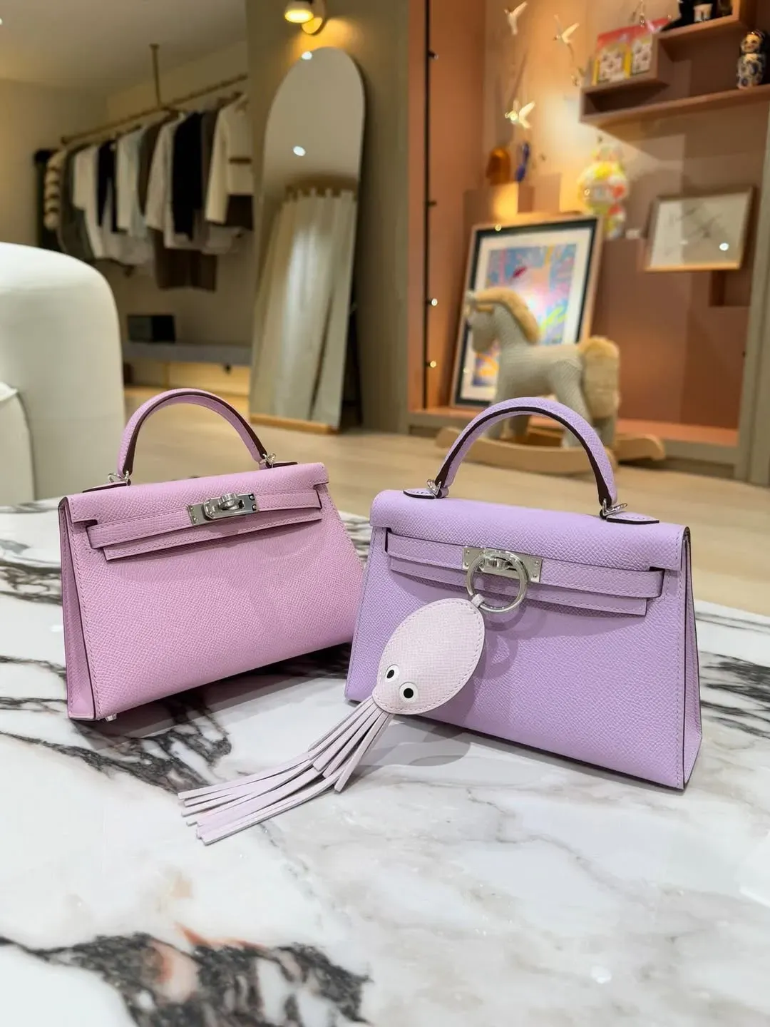 左:Hermès Mini Kelly II Guimauve(棉花糖粉)Epsom皮革實物圖片;右:Hermès Mini Kelly II Mauve Sylvestre Epsom皮革實物圖片。兩者同屬柔和粉色系,但Guimauve整體更偏清透粉紫調,減少Mauve Sylvestre較成熟冷冽嘅紫色感;於Epsom皮革細緻壓紋下,兩款顏色嘅明度及飽和度差異更為明顯。