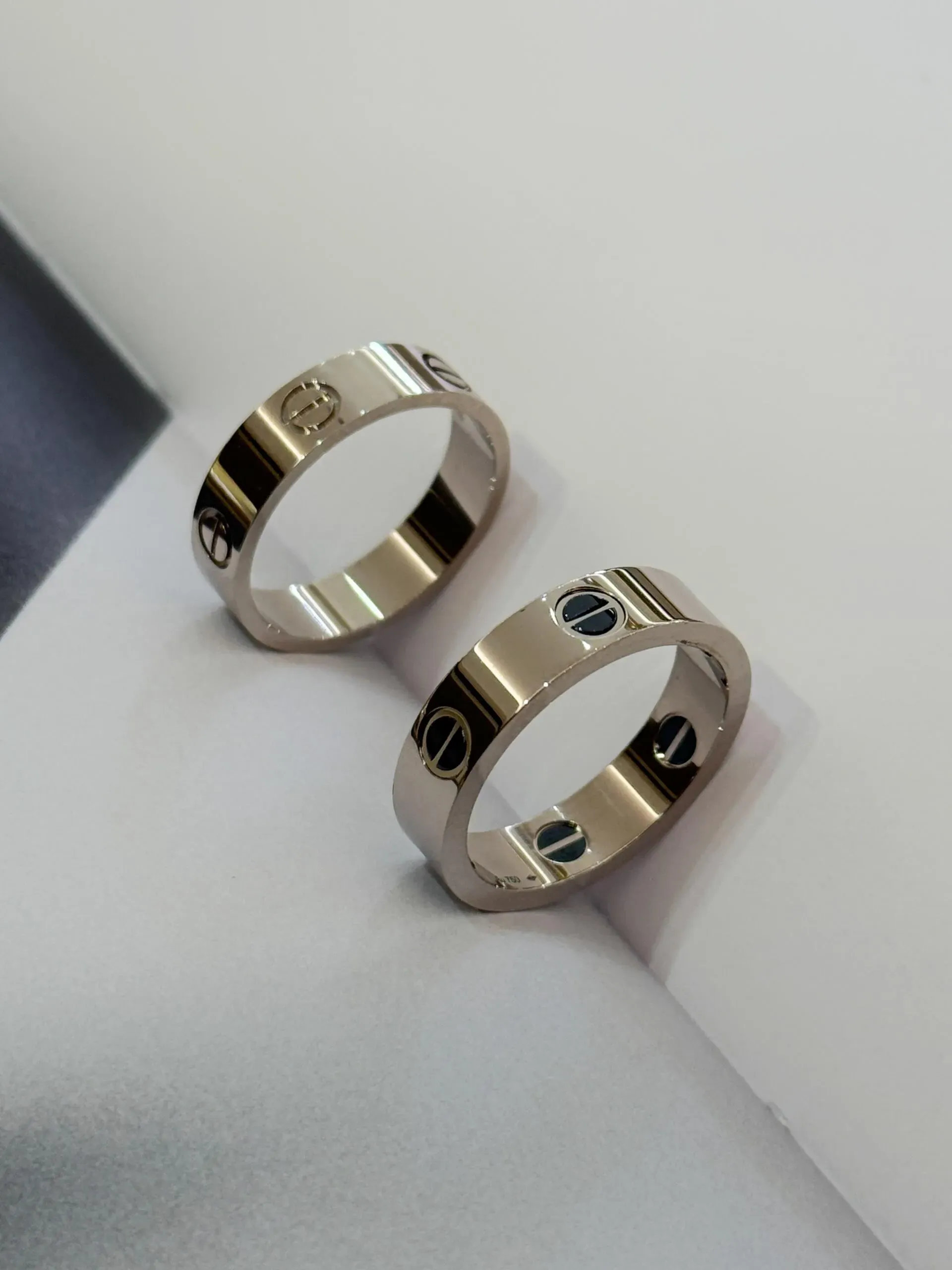 LOVE戒指,經典款,陶瓷與LOVE戒指,經典款實物對比圖,展示同一設計於黑陶瓷及純18K白金材質下的外觀差異。