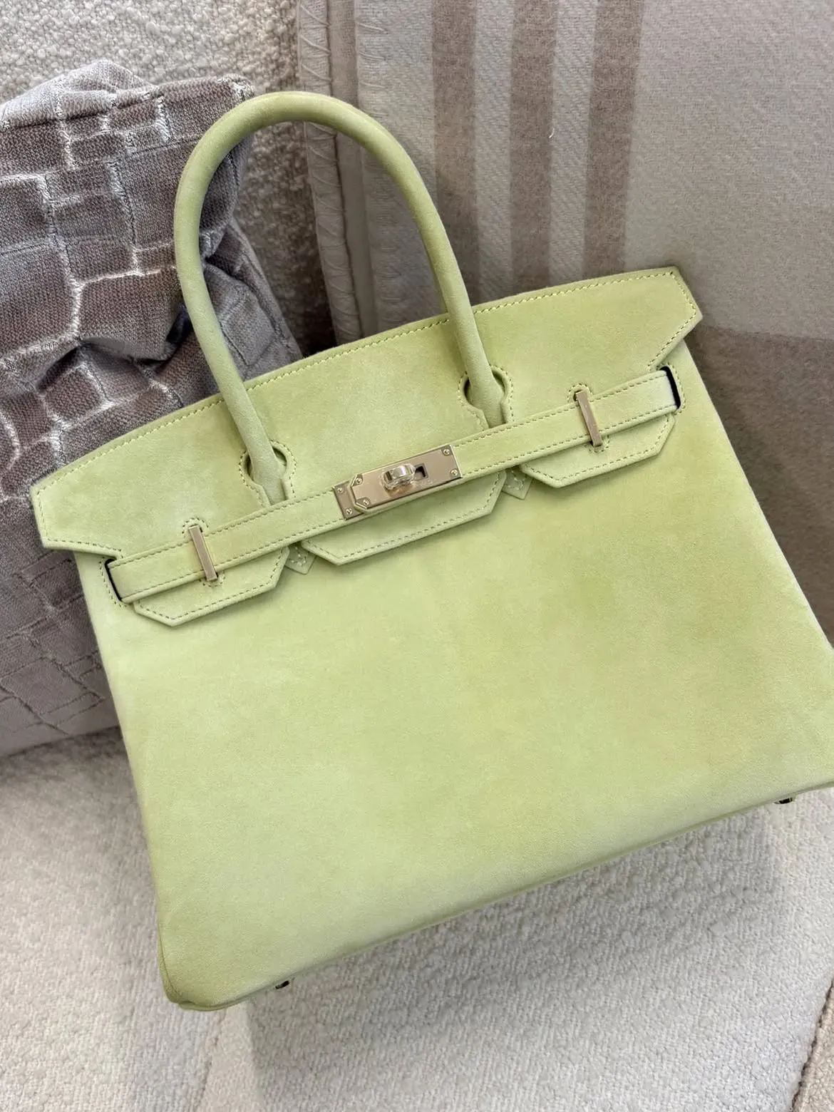 Hermès Birkin Tilleul（椴樹綠）Doblis&nbsp;麂皮配&nbsp;Permabrass（PBHW，香檳金色五金）。由光面皮革到麂皮，PBHW&nbsp;都展現出較柔和、內斂嘅金屬光澤，亦反映佢並非只適合某一種皮革，而係能配合不同材質呈現截然不同嘅質感。